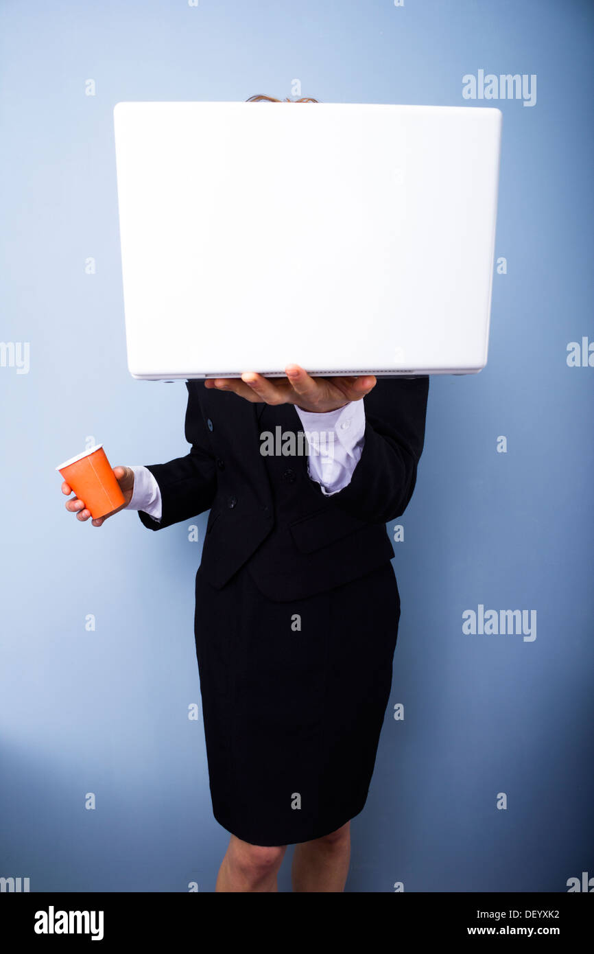 Geschäftsfrau, versteckt sich hinter ihrem Laptop und trinken Kaffee aus einem Pappbecher Stockfoto