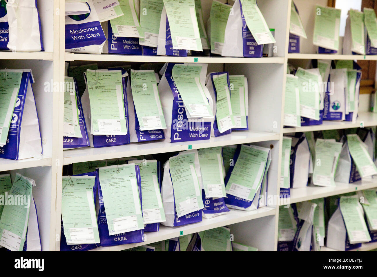 Vorschriften im Vereinigten Königreich; NHS verschreibungspflichtige Medikamente warten auf eine Apotheke Apotheke Regale, Suffolk, England, Großbritannien gesammelt werden Stockfoto