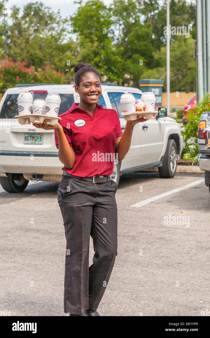 Server Bereitstellung von Milch-Shakes zu wartenden Autos an der Chick-Fil-a Fast-Food-Restaurant in Ocala, FL, christliche Ethik zu unterstützen Stockfoto