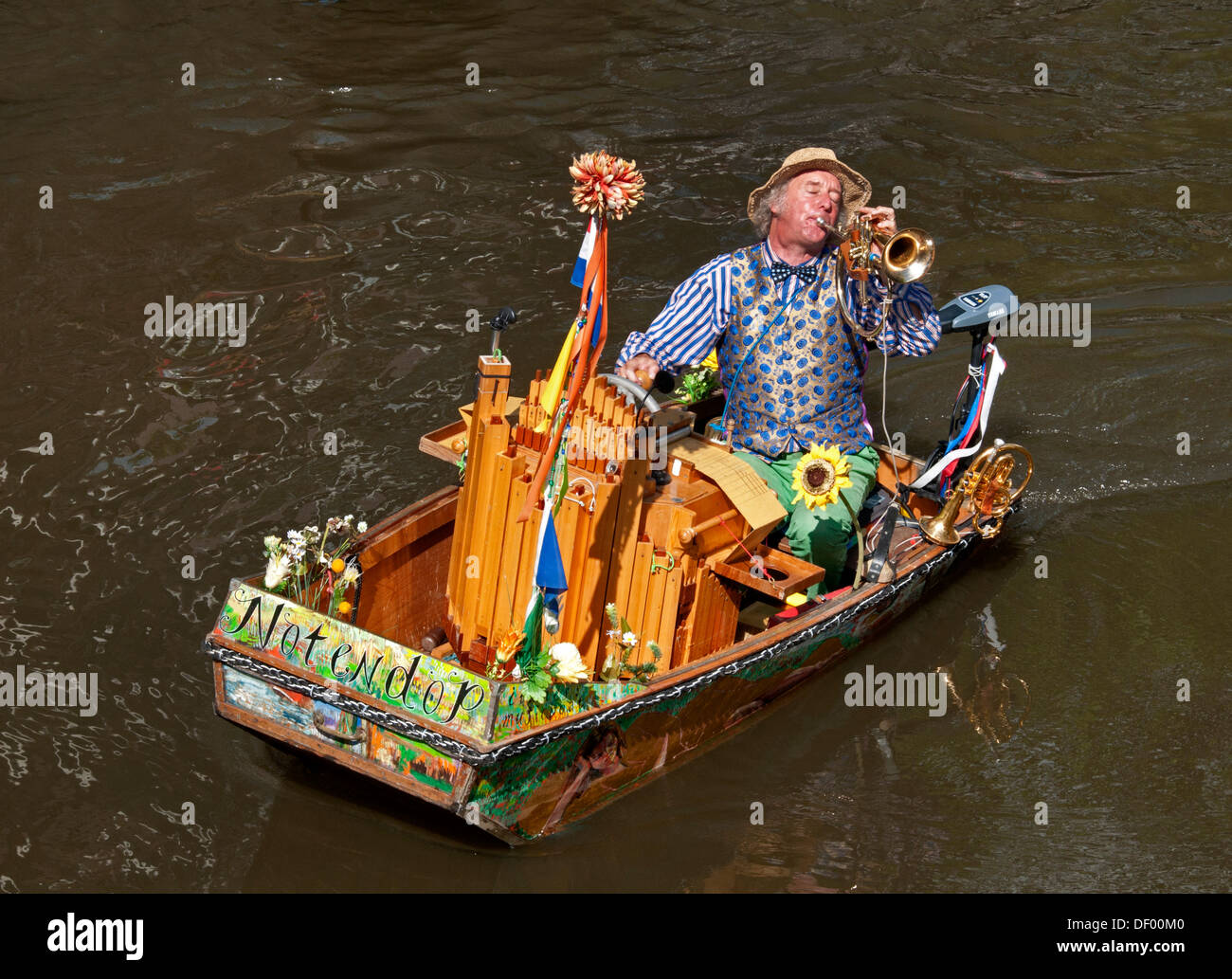 Ein Straßenmusikant (Reinier Sijpkens) Trompete in einem Organ Boot an einer Gracht in Amsterdam Niederlande Stockfoto