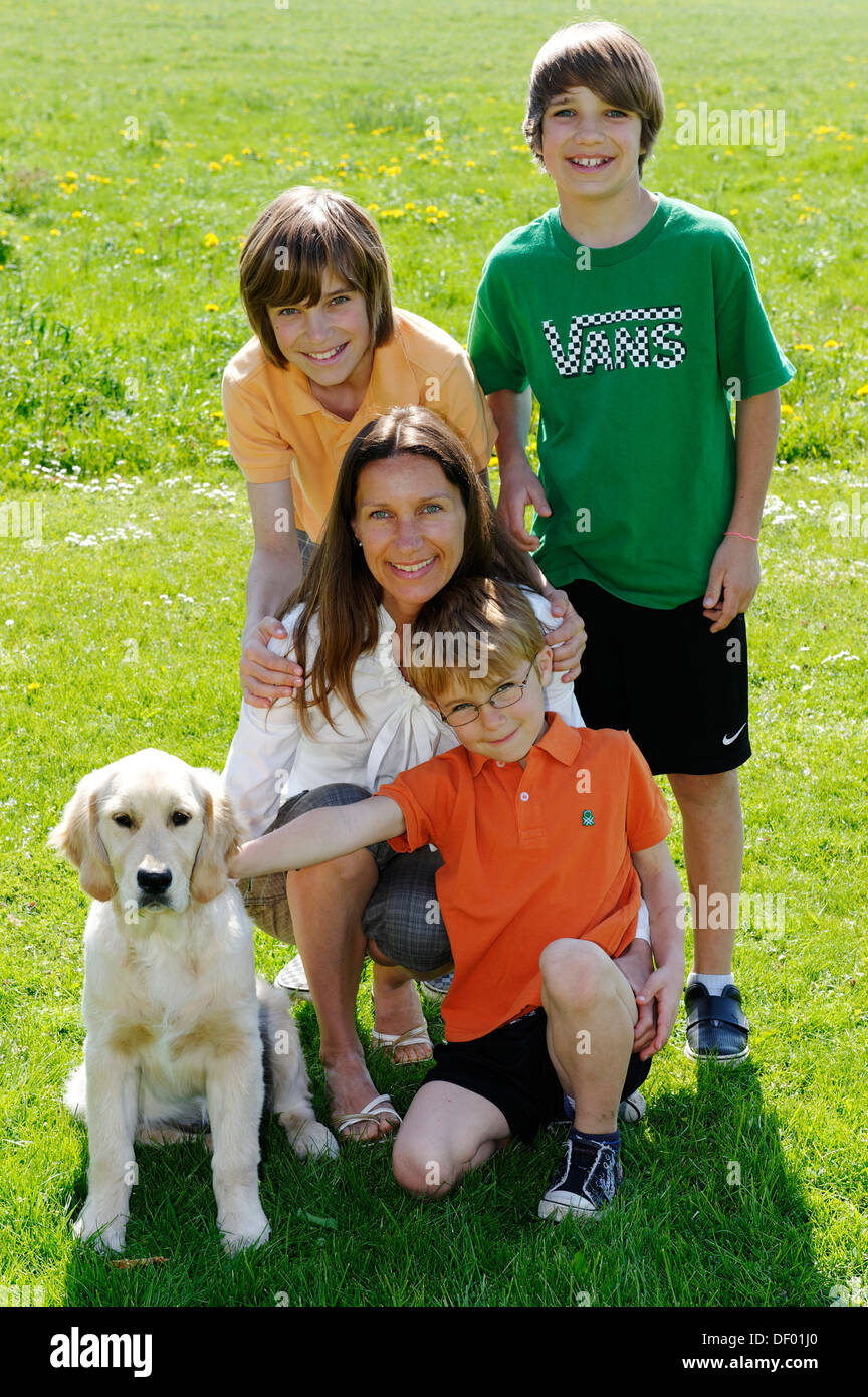 Mutter mit ihren drei Söhnen und ein Hund Stockfoto