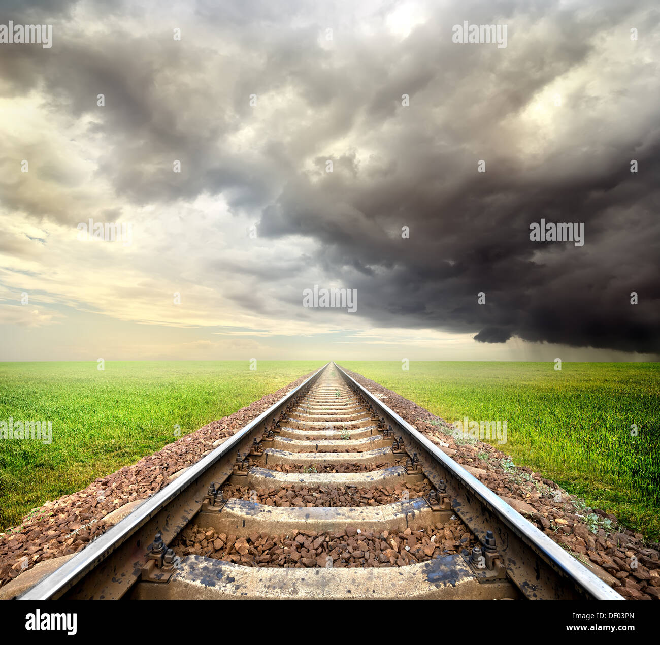 Eisenbahn in das Feld und Gewitterwolken Stockfoto