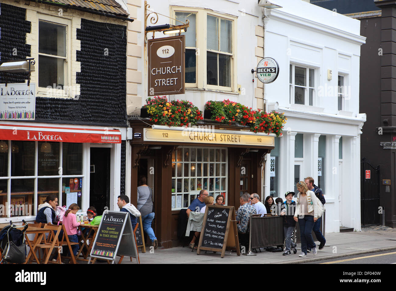 Leute sitzen draußen essen und trinken in Straßencafés und Restaurants in Brighton Stockfoto