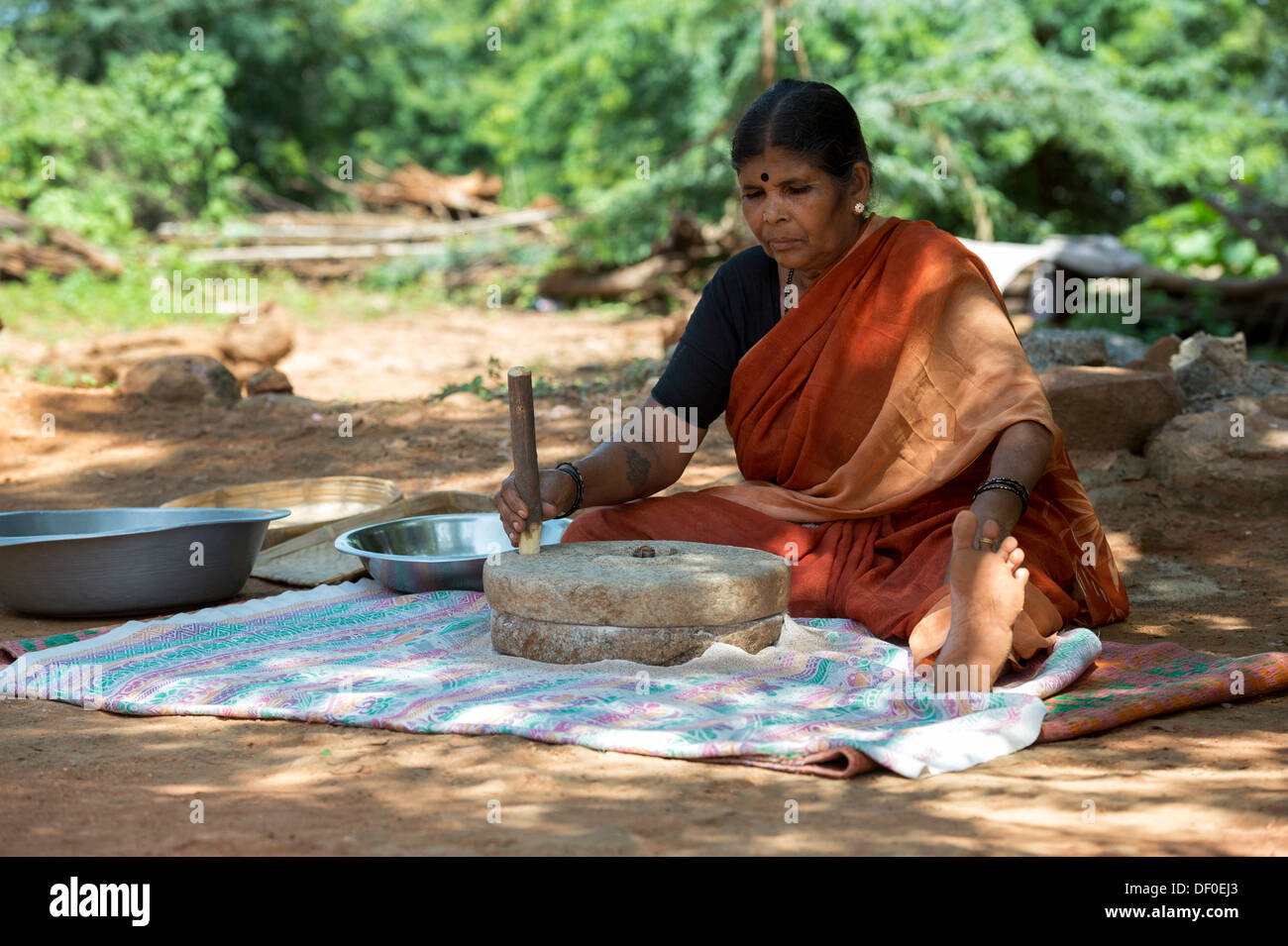 Ländliche Indianerdorf Frauen mit Mahlsteinen Steinen Fingerhirse Samen mahlen / Ragi-Hirse Samen zu Ragi-Hirse-Mehl. Andhra Pradesh. Indien Stockfoto