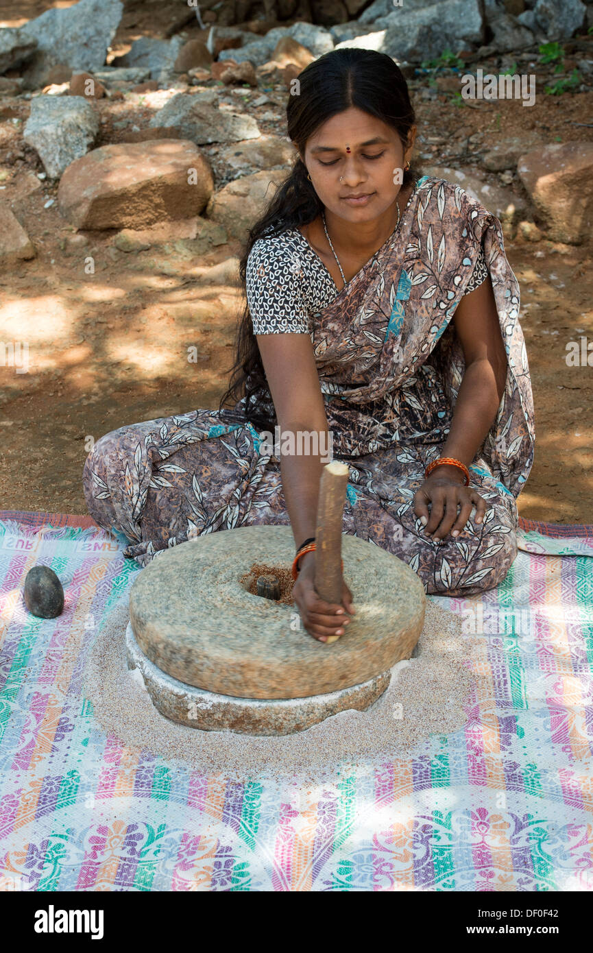 Indische Dorf Frau mit Mahlsteinen Steinen Fingerhirse Samen mahlen / Ragi-Hirse Samen zu Ragi-Hirse-Mehl. Andhra Pradesh. Indien Stockfoto