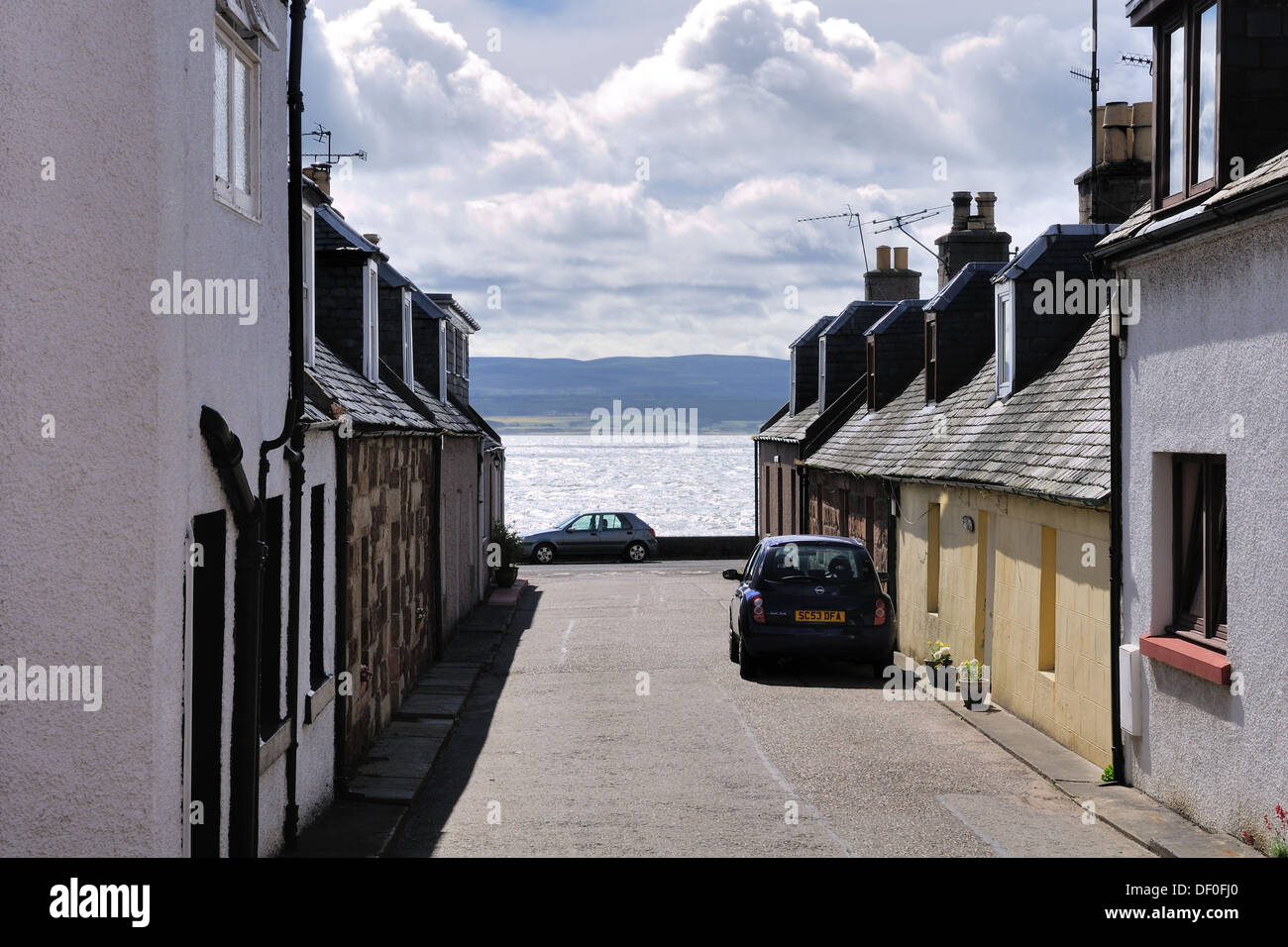 Eine schmale Straße von kleinen Hütten läuft in Richtung Beauly Firth. Stockfoto