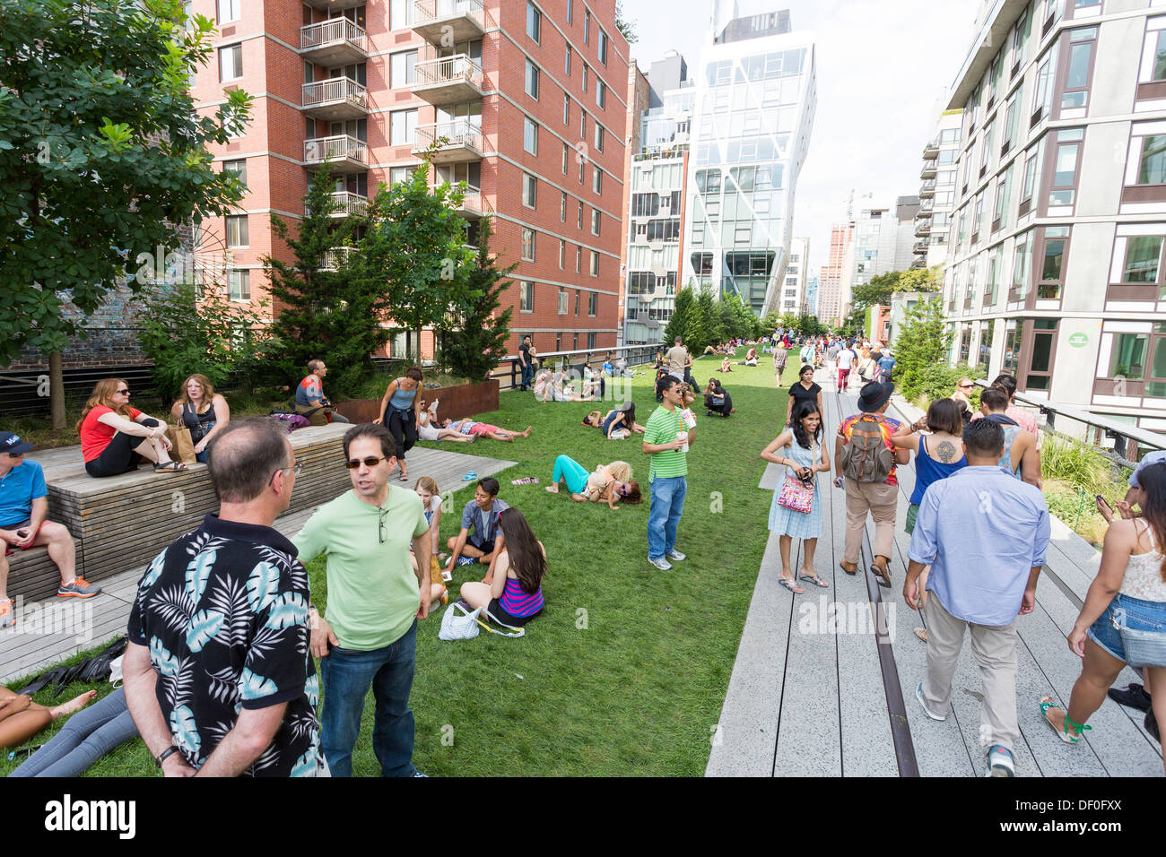 Menschen genießen einen sonnigen Tag auf der High Line Bürgerpark erhaben über die Straßen auf der West Side Manhattan Stockfoto