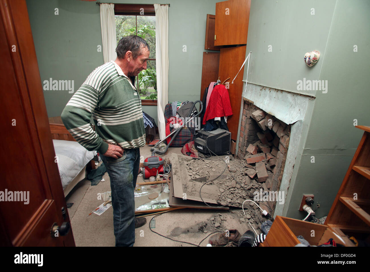 Ein Mann in seinem beschädigten Haus fiel auf den Tag nach einem schweren Erdbeben Seddon, Marlborough, Neuseeland Stockfoto