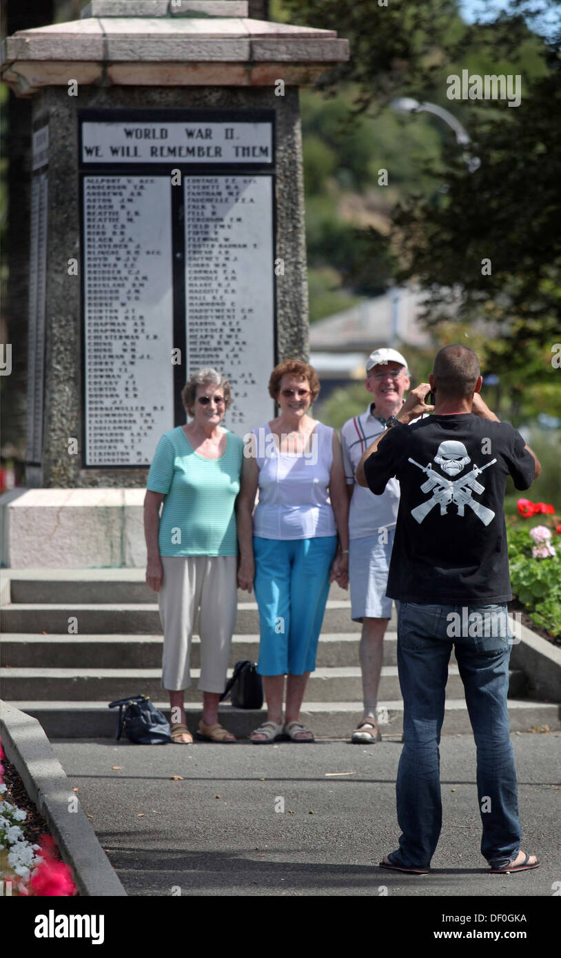 Mann trägt eine Geschütze und Totenkopf Design fotografiert Touristen am Kriegerdenkmal ANZAC Park, Nelson, Neuseeland Stockfoto