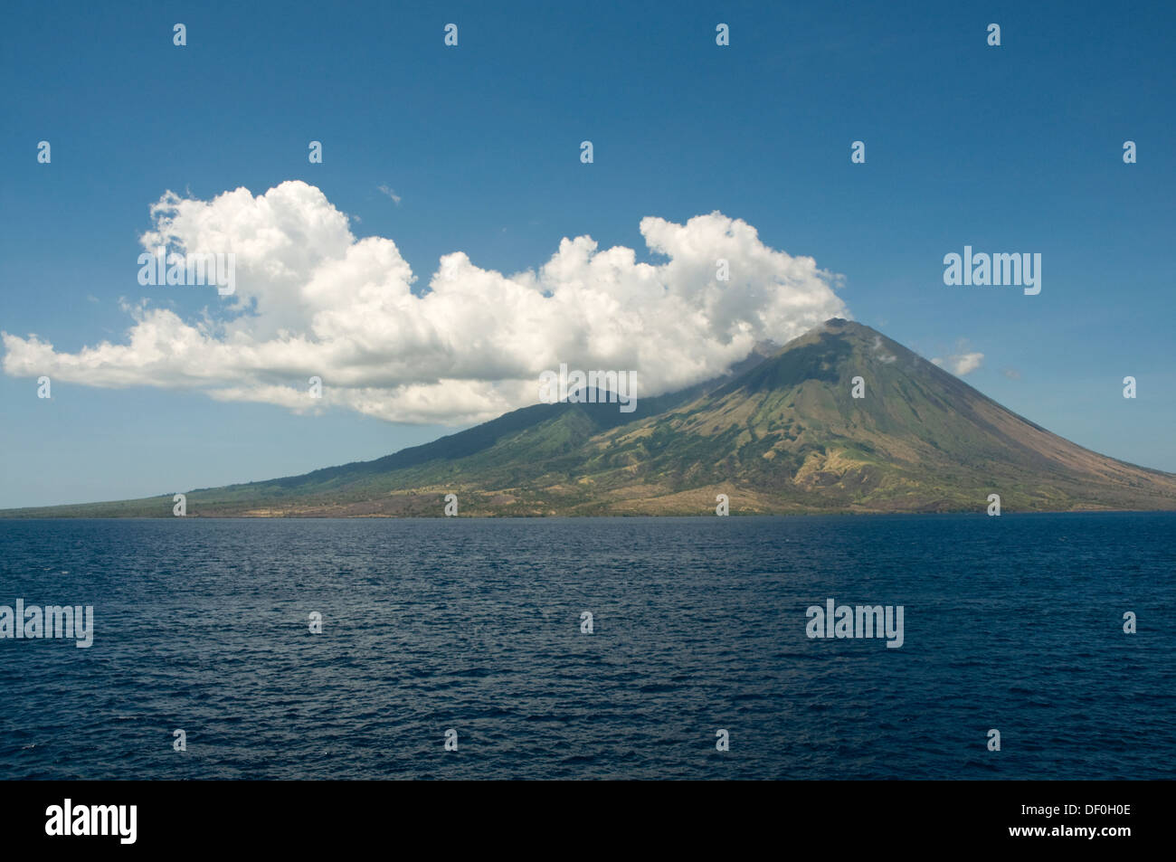 Indonesien, Insel Sumbawa, Vulkan mit Wolken und blauer Himmel im Bild aus dem Meer Stockfoto