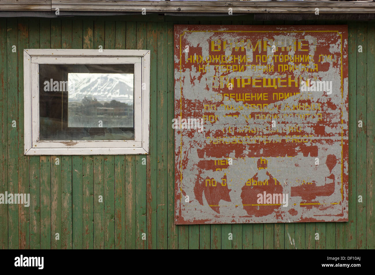 Bemalte grün Holzgebäude mit einem abgenutzten russische Zeichen in kyrillischer Schrift auf der verlassenen sowjetischen russischen Bergbausiedlung Pyramiden, Spitzbergen, Svalbard-Archipel, Norwegen Stockfoto