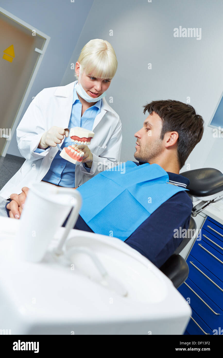 Zahnärztin Zahnbehandlung mit Zahnersatz, einen Patienten zu erklären Stockfoto