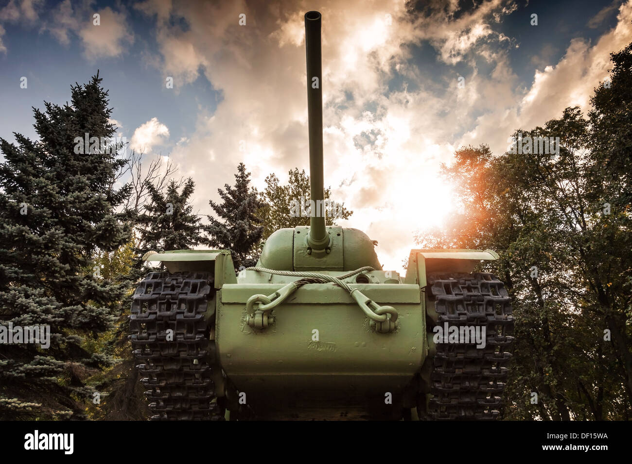 Schwere sowjetische KV-85 Panzer aus dem zweiten Weltkrieg mit Wald und dramatischer Himmel auf einem Hintergrund. Denkmal in St. Petersburg Stockfoto
