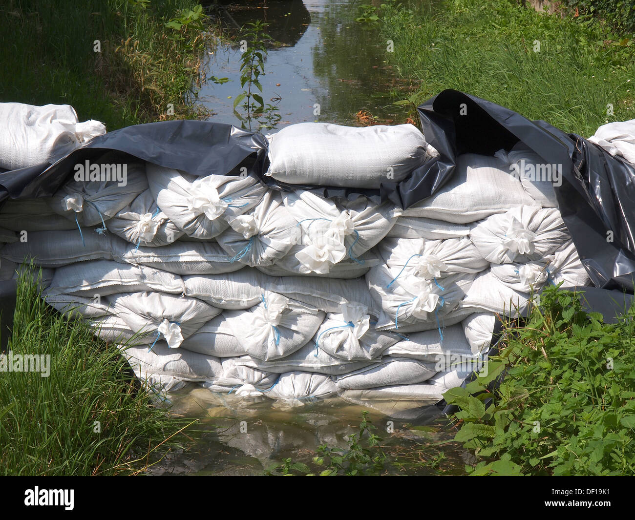 Weiße Sandsäcke für Hochwasserschutz Verteidigung und braune Wasser Stockfoto