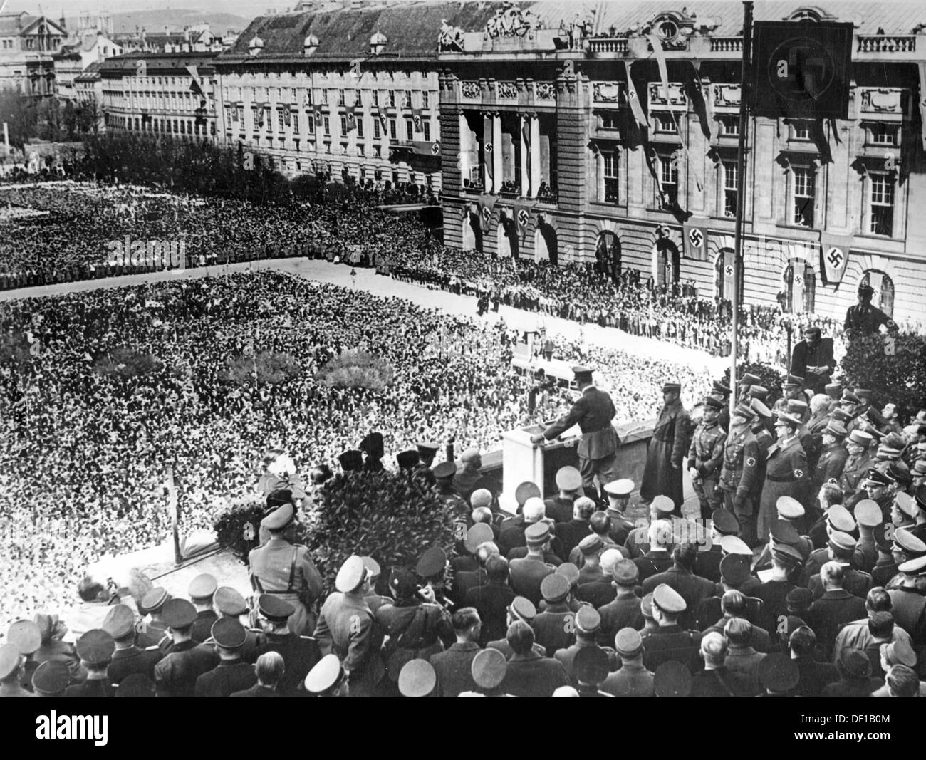 Das Bild der Nazi-Propaganda! Adolf Hitler auf dem Balkon der Hofburg verkündet am 15. März 1938 die Annexion Österreichs in das Deutsche Reich vor der Menschenmenge auf dem Heldenplatz in Wien. Fotoarchiv für Zeitgeschichte Stockfoto
