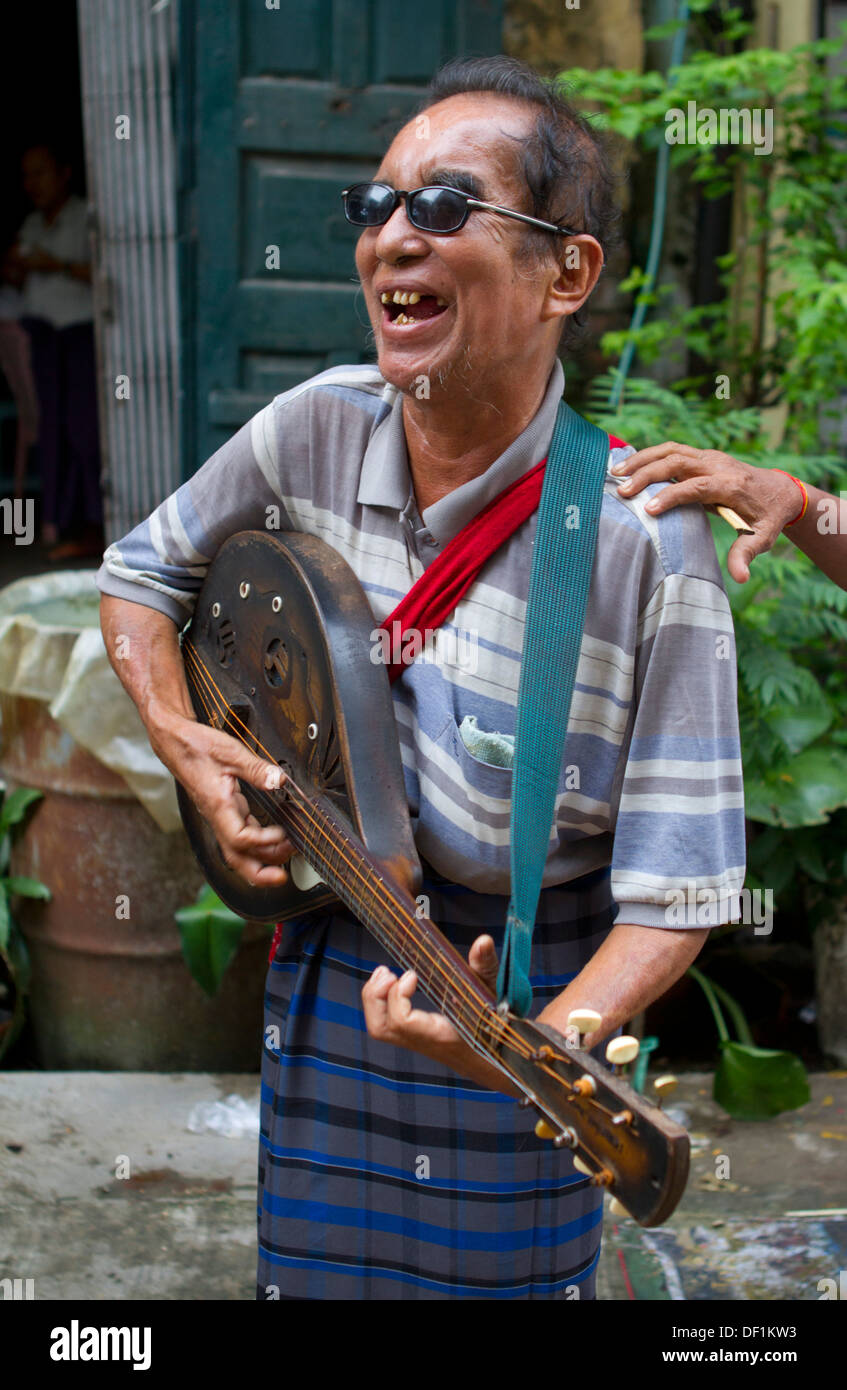 Ein blinder Mann spielt Gitarre für Geld in Yangon, Birma. Stockfoto