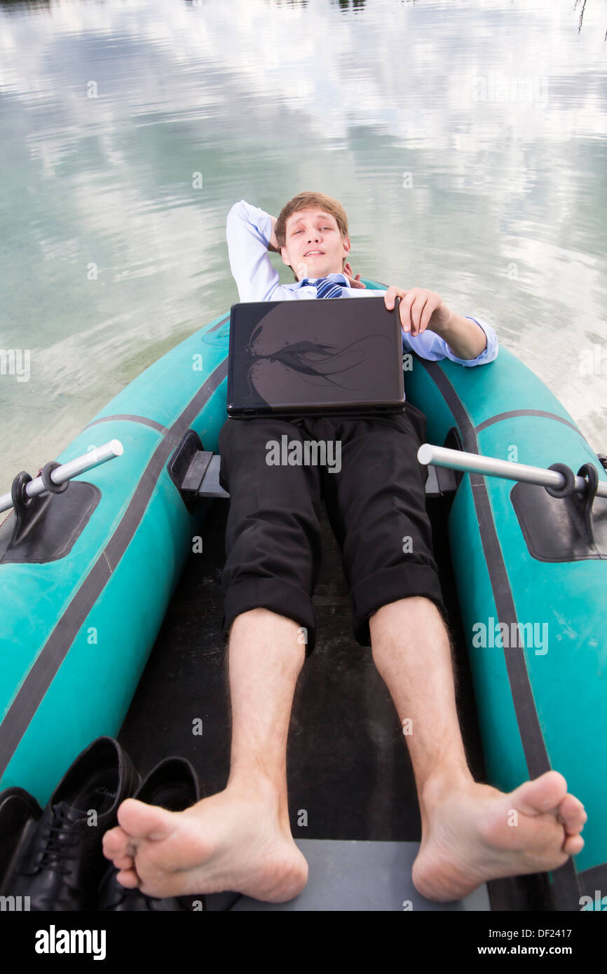 Gekleidete Mann lag im Boot und nehmen Sie sich Zeit Stockfoto