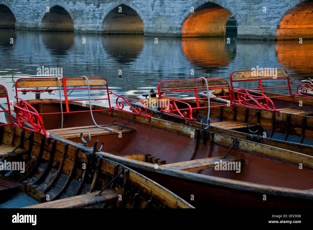Hölzerne Dayhire Boote vertäut am Fluss Avon im Schatten des Clopton Brücke, Stratford-upon-Avon, Warwickshire. Stockfoto