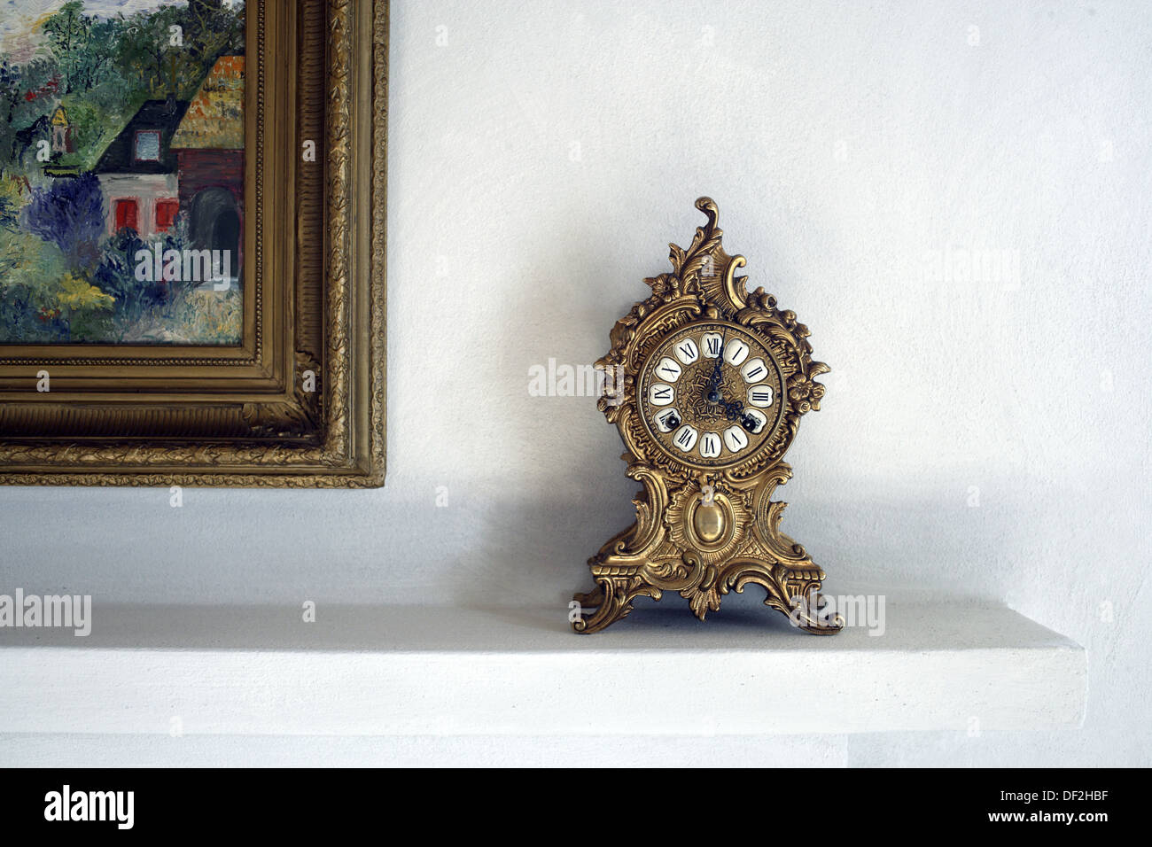 Alte antike Uhr stehen auf dem Kaminsims einen Kamin neben einem bunten Gemälde des berühmten Malers Monet, Gabiano, Stockfoto