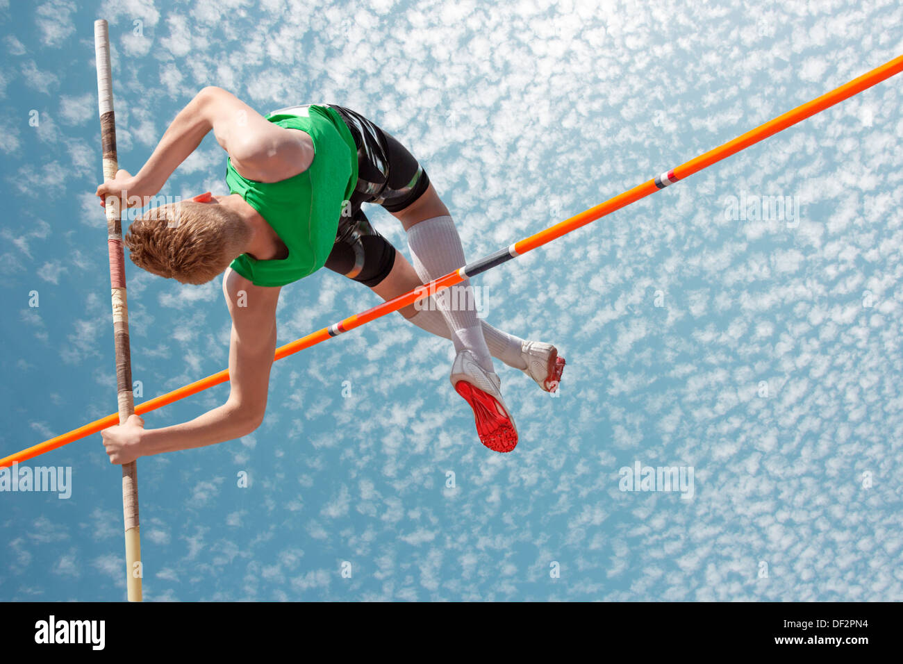 Junge Sportler Stabhochsprung scheint den Himmel erreichen Stockfoto