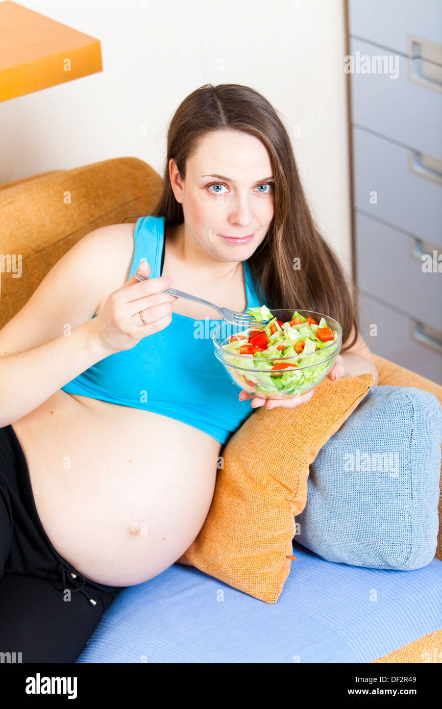 Schwangere Mädchen isst frisches Gemüse Stockfoto