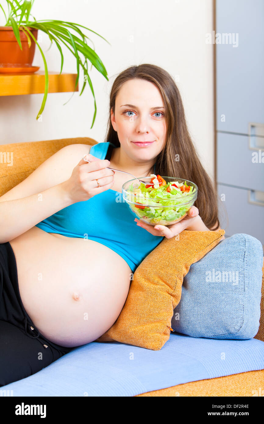Schwangere Mädchen isst frisches Gemüse Stockfoto