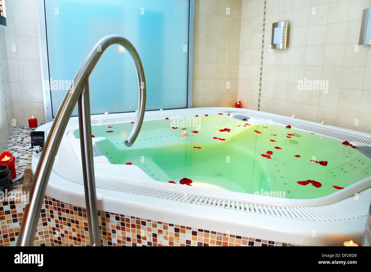 Badewanne mit Whirlpool mit Blütenblättern von Rosen Stockfoto