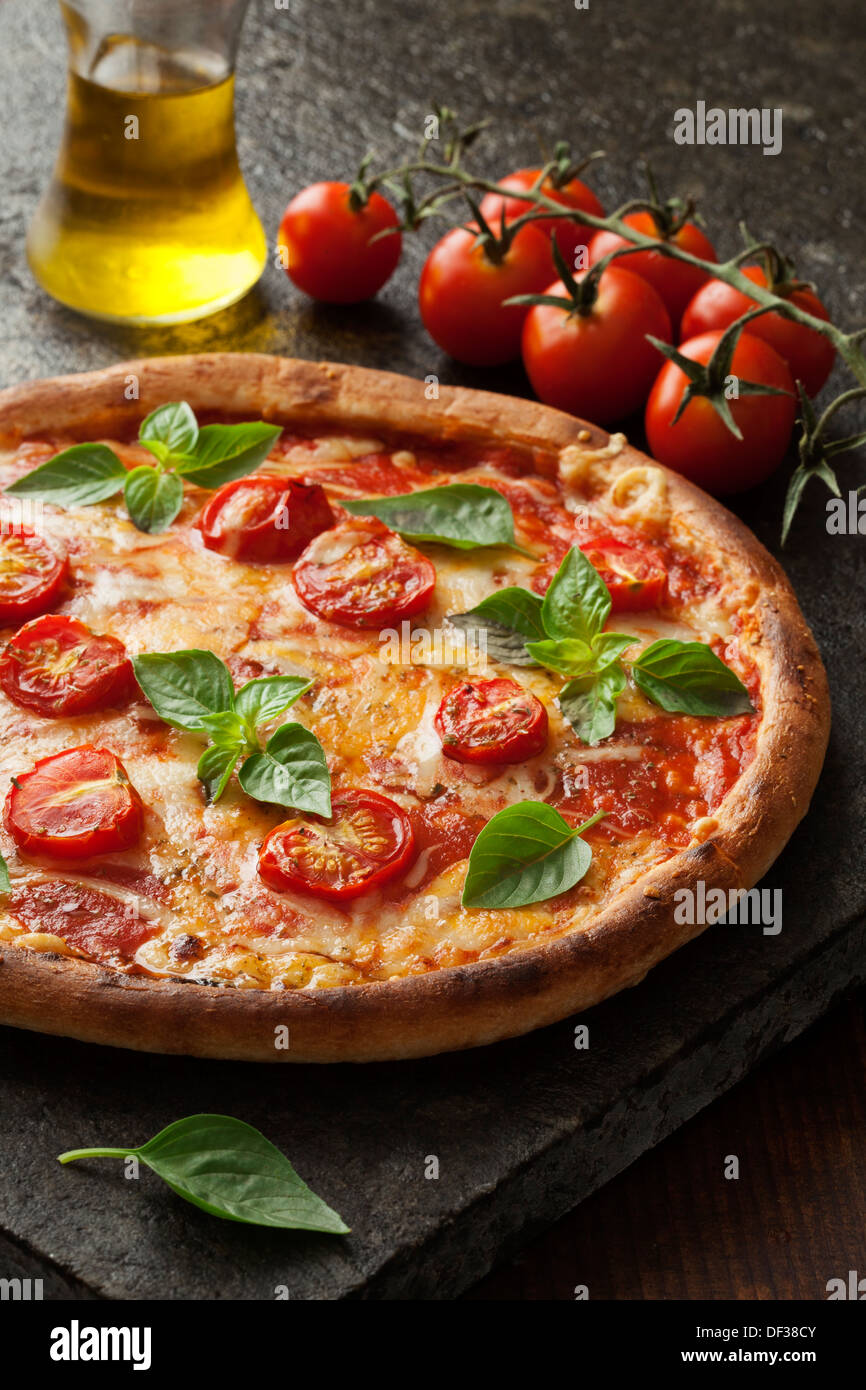 rustikale italienische Pizza mit Mozzarella, Käse und Basilikum Blätter Stockfoto