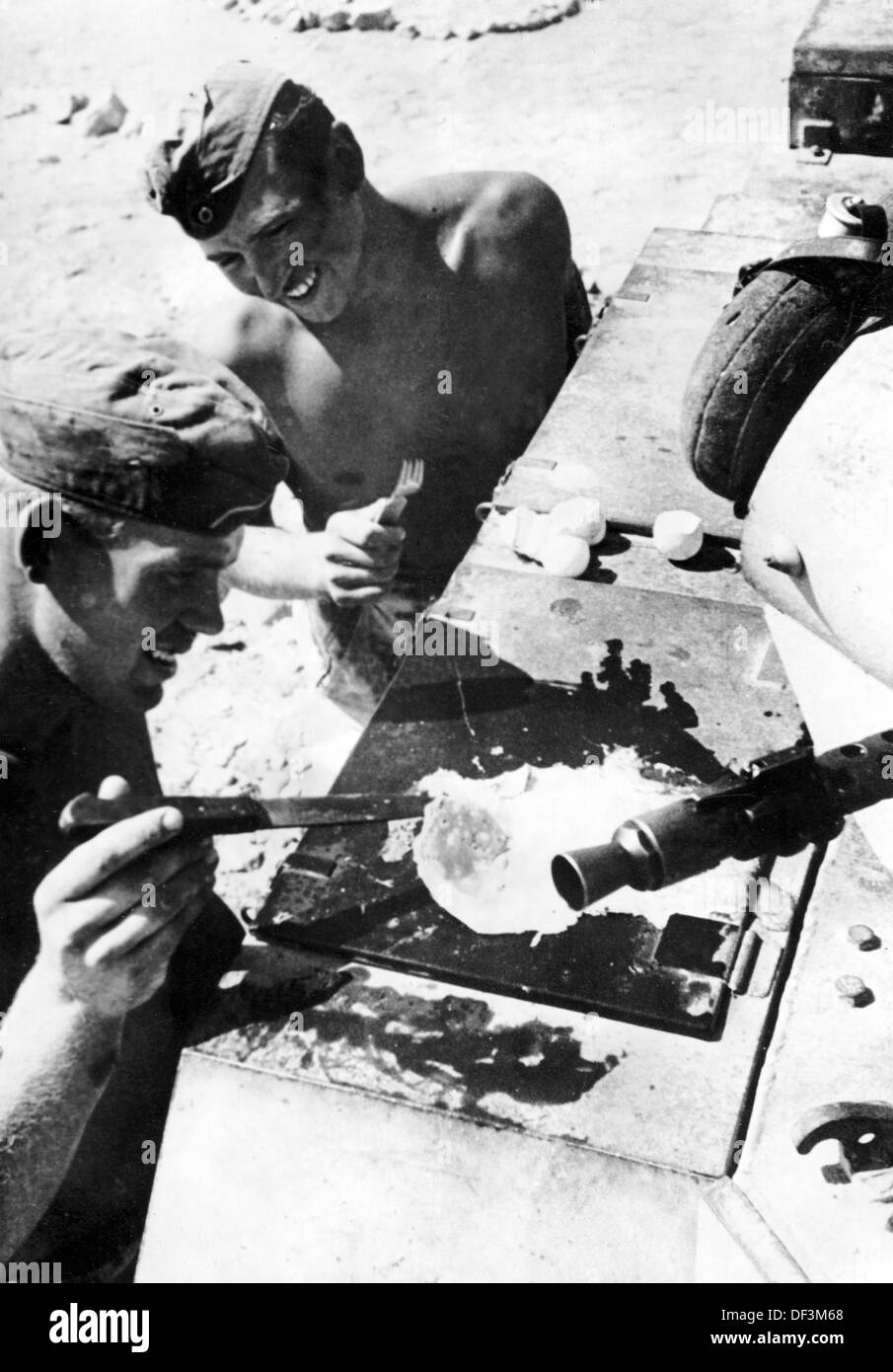 Das Bild der Nazi-Propaganda! Zeigt Soldaten der deutschen Wehrmacht, die ein Ei auf dem heißen Metall eines Panzers braten, veröffentlicht am 11. Oktober 1941. Ort unbekannt. Fotoarchiv für Zeitgeschichte Stockfoto