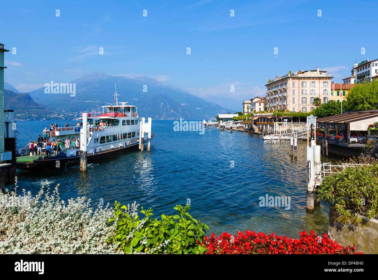 Comer See. Fähre am Dock mit historischen Hotel Genazzini entladen / Metropole am Wasser nach rechts, Bellagio, Lombardei, Italien Stockfoto