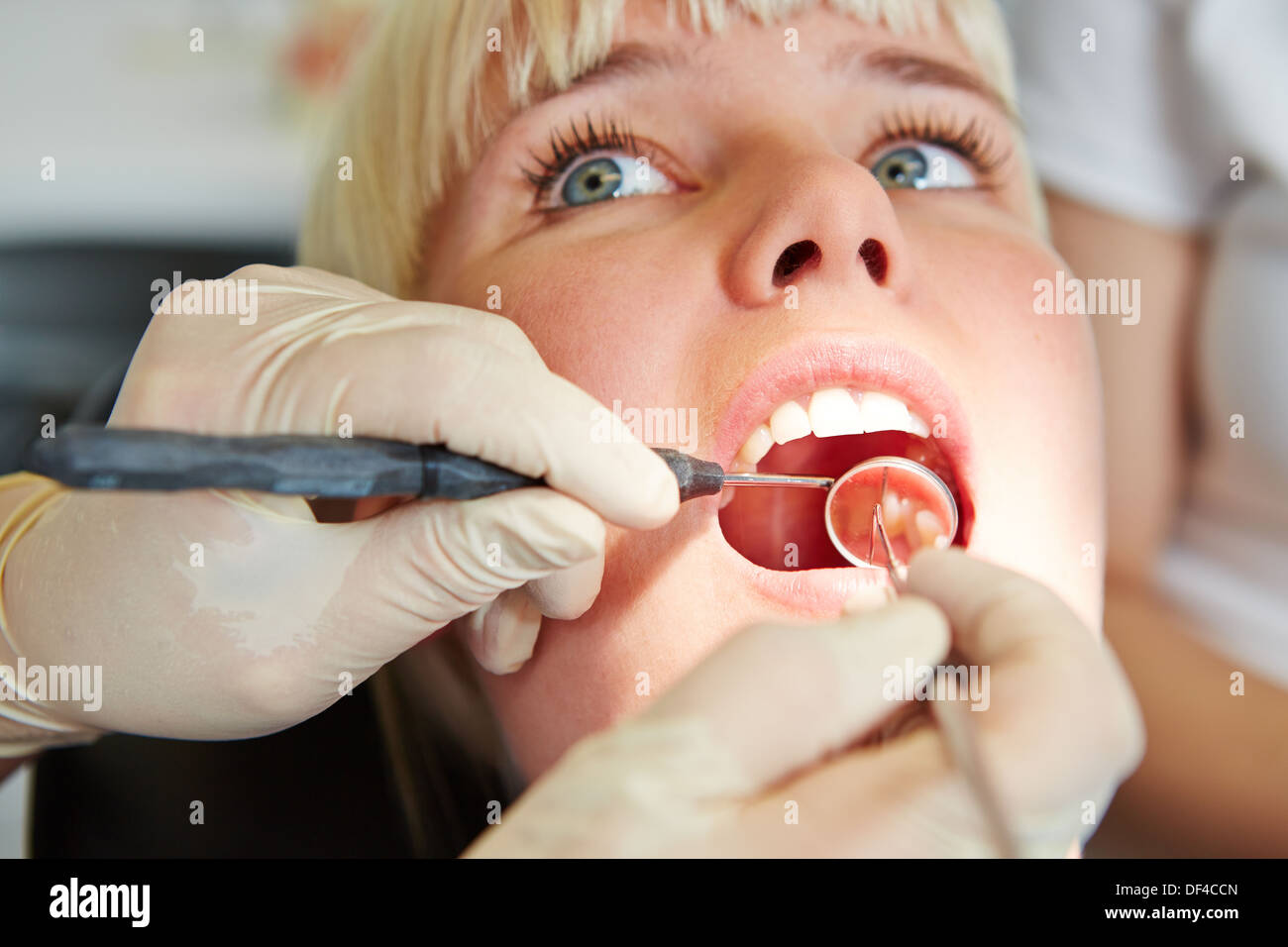 Hände des Zahnarztes mit Sonde und Spiegel im Mund des Patienten Stockfoto