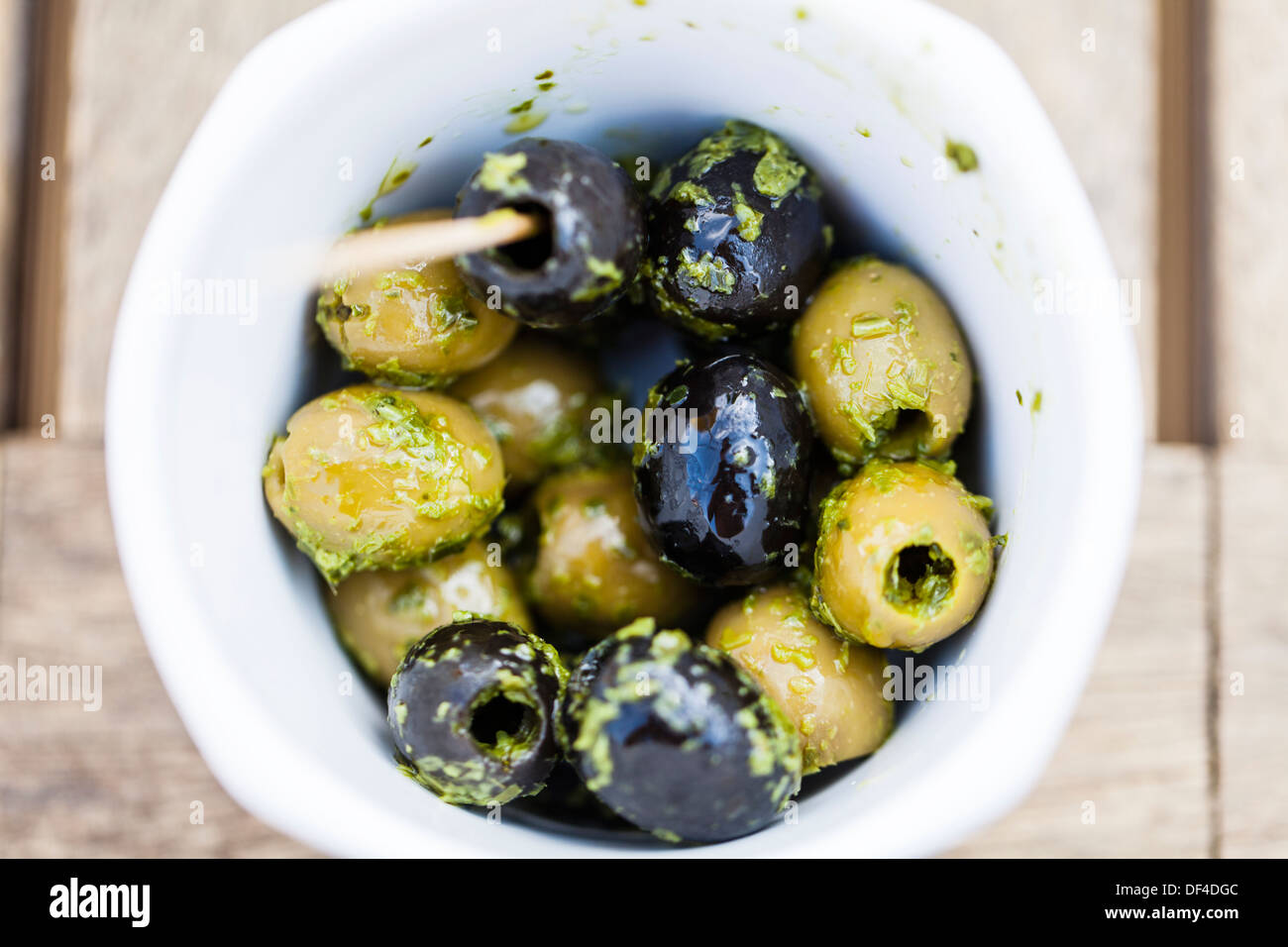 Lecker, schwarze und grüne Oliven in kleine Schüssel mit Öl und Kräuter Dressing Stockfoto