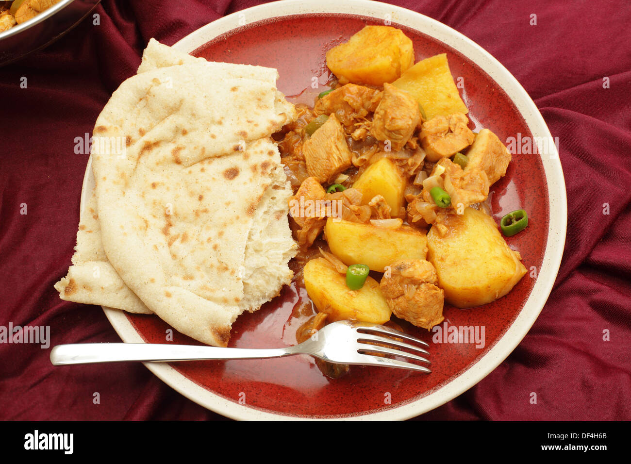 Goan Huhn und Kartoffeln Vindaloo Curry, in Essig und Gewürz Sauce gekocht und serviert mit einer Scheibe Fladenbrot Stockfoto