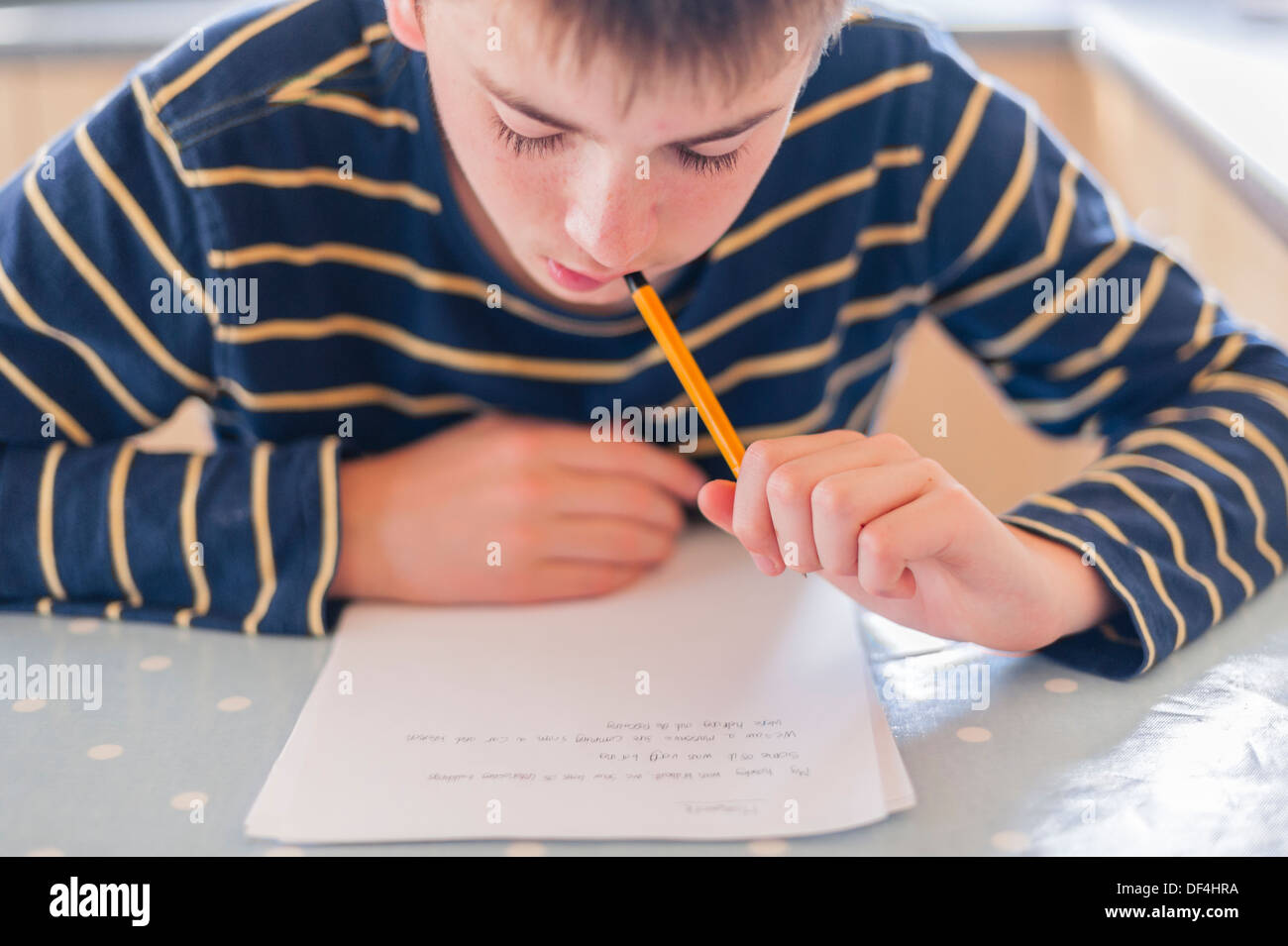 Ein 13 Jahre alter Junge, der seine Hausaufgaben in der Küche Stockfoto