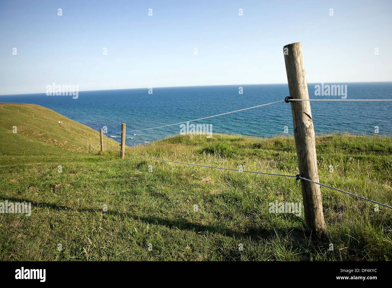 Seil-Zaun entlang der hügeligen Küste Stockfoto