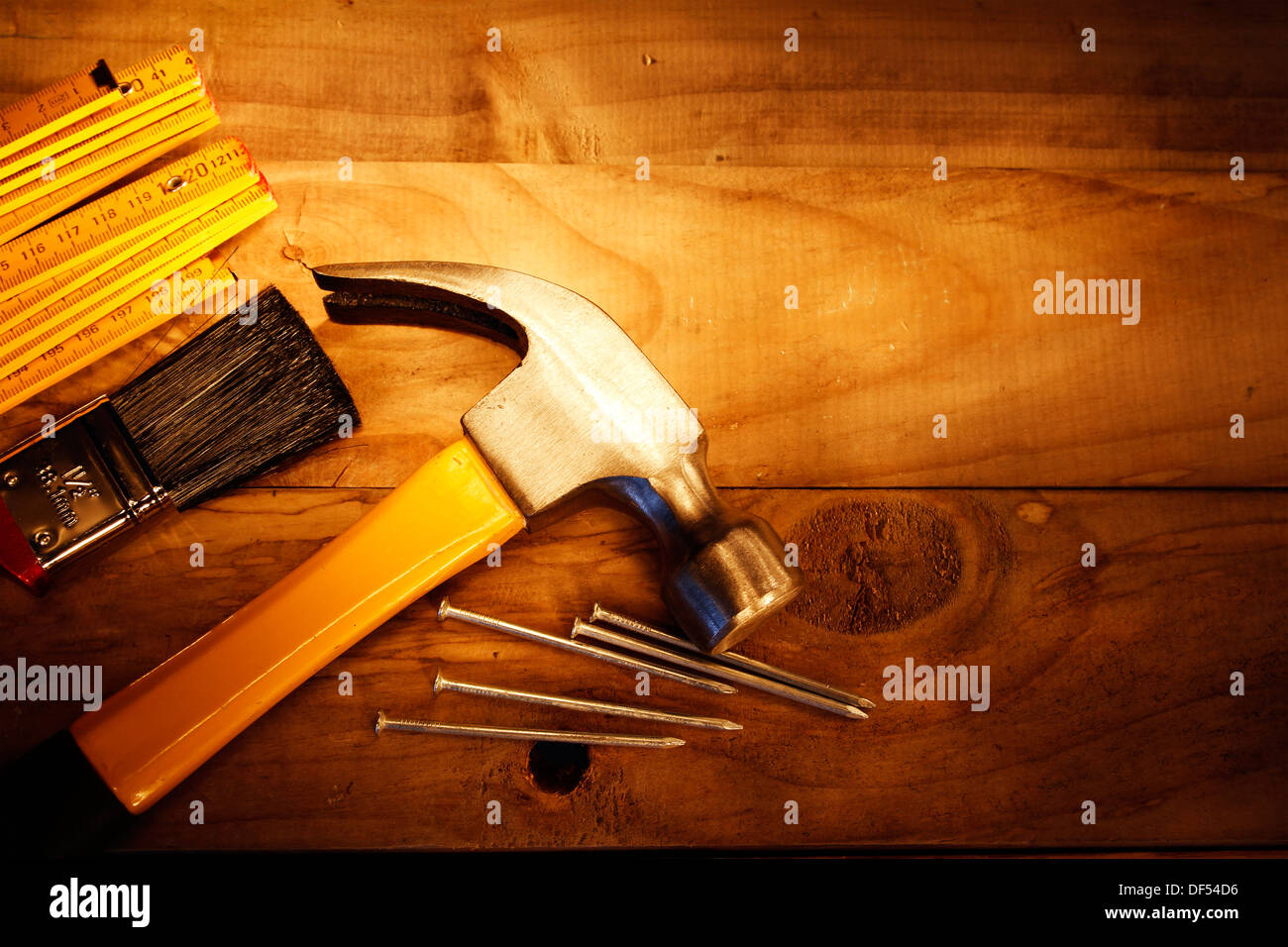 Hammer, Nägel, Lineal und Pinsel auf Holz Stockfoto