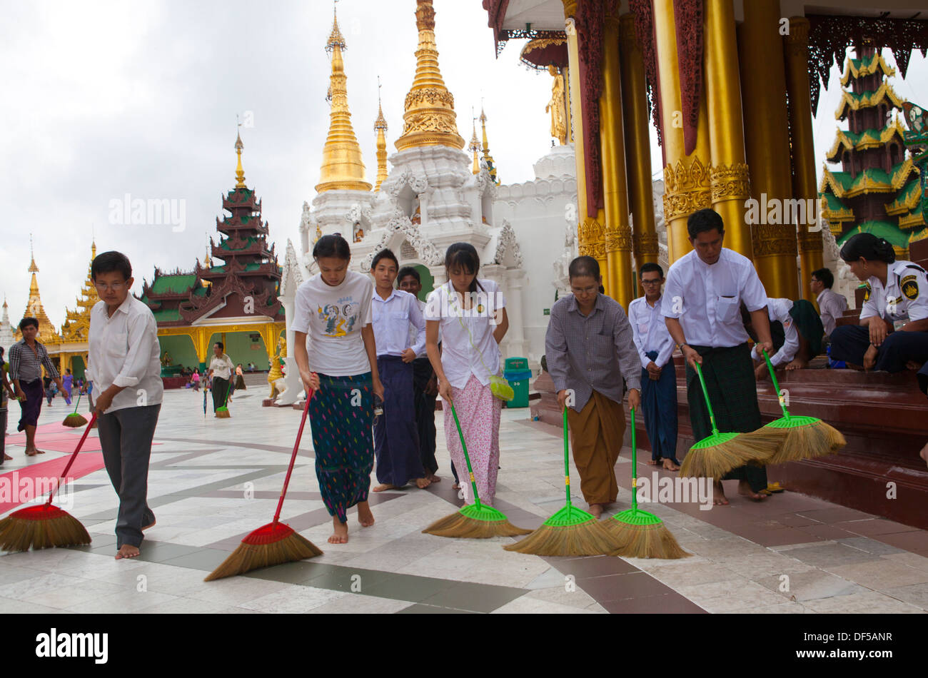 Menschen fegen den Boden auf Shwedagon Paya im nördlich-zentralen Yangon, Birma. Stockfoto