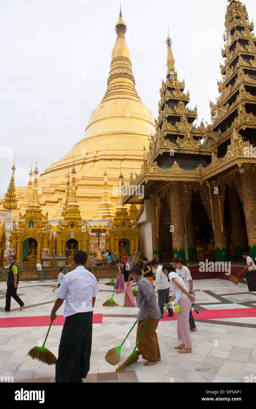 Menschen fegen den Boden auf Shwedagon Paya im nördlich-zentralen Yangon, Birma. Stockfoto