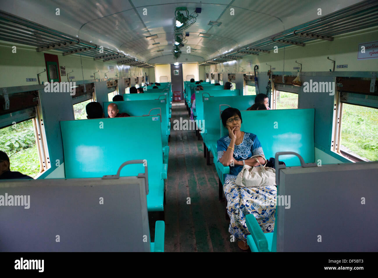 Personen fahren in einem Eisenbahnwaggon in Yangon, Birma. Stockfoto