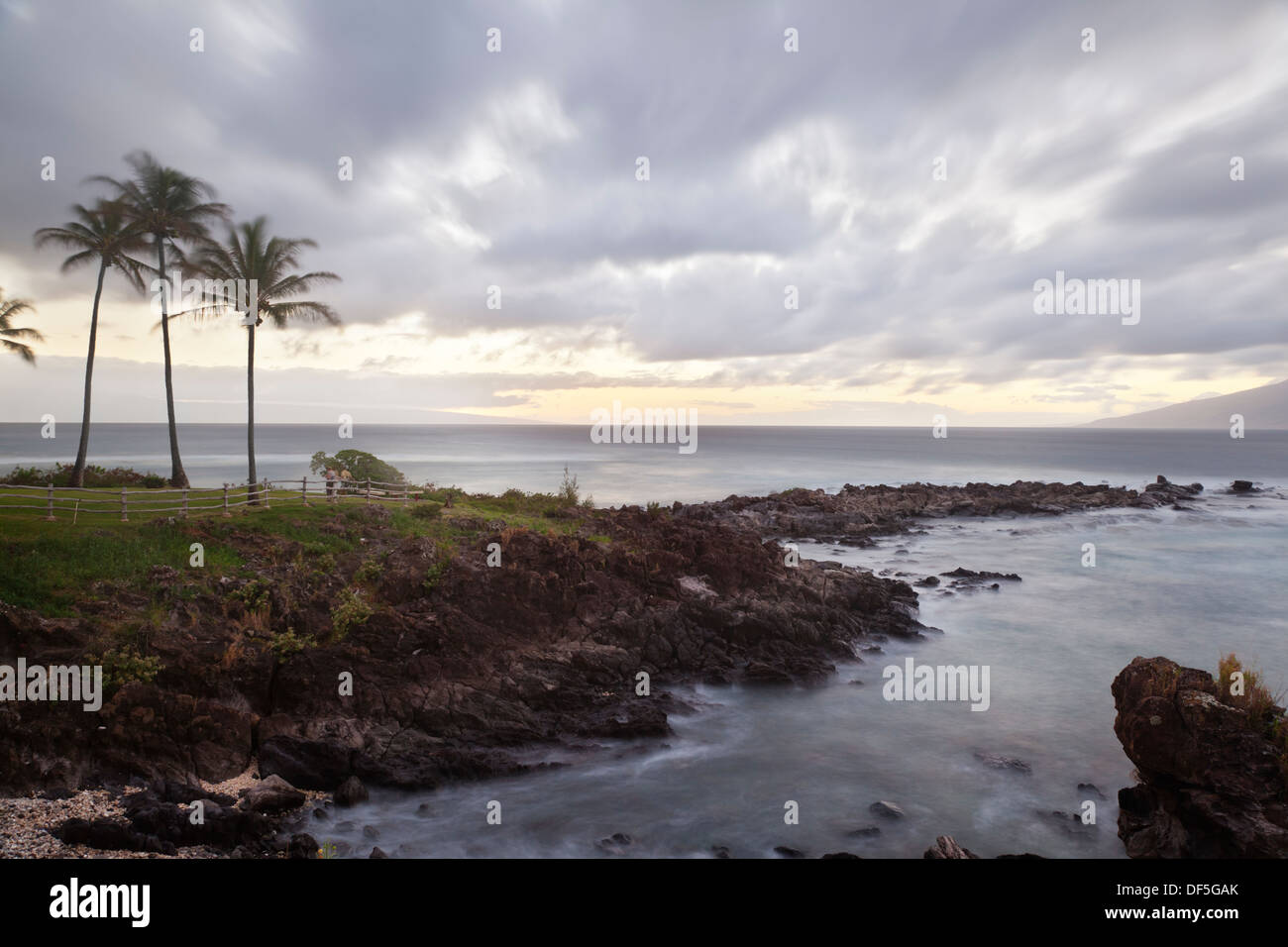 Langzeitbelichtung an Napili Punkt mit Kokosnuss-Palmen bei Sonnenuntergang in Maui, Hawaii. Stockfoto