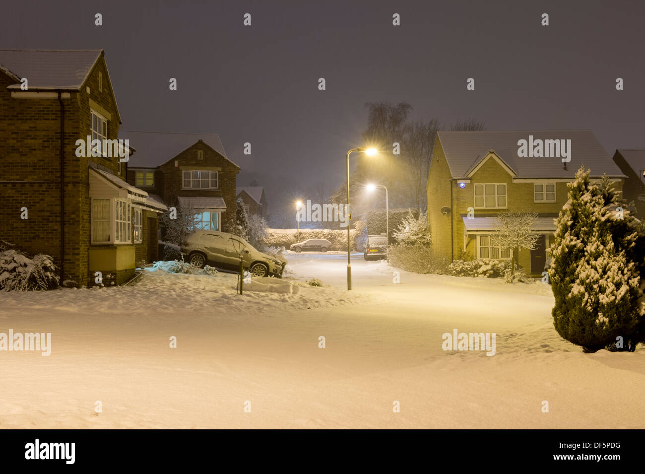 Starburst Licht von steet Lampen nachts Private moderne Häuser im kalten, schneebedeckten cul-de-sac-Burley in Bösingen, England, UK. Stockfoto
