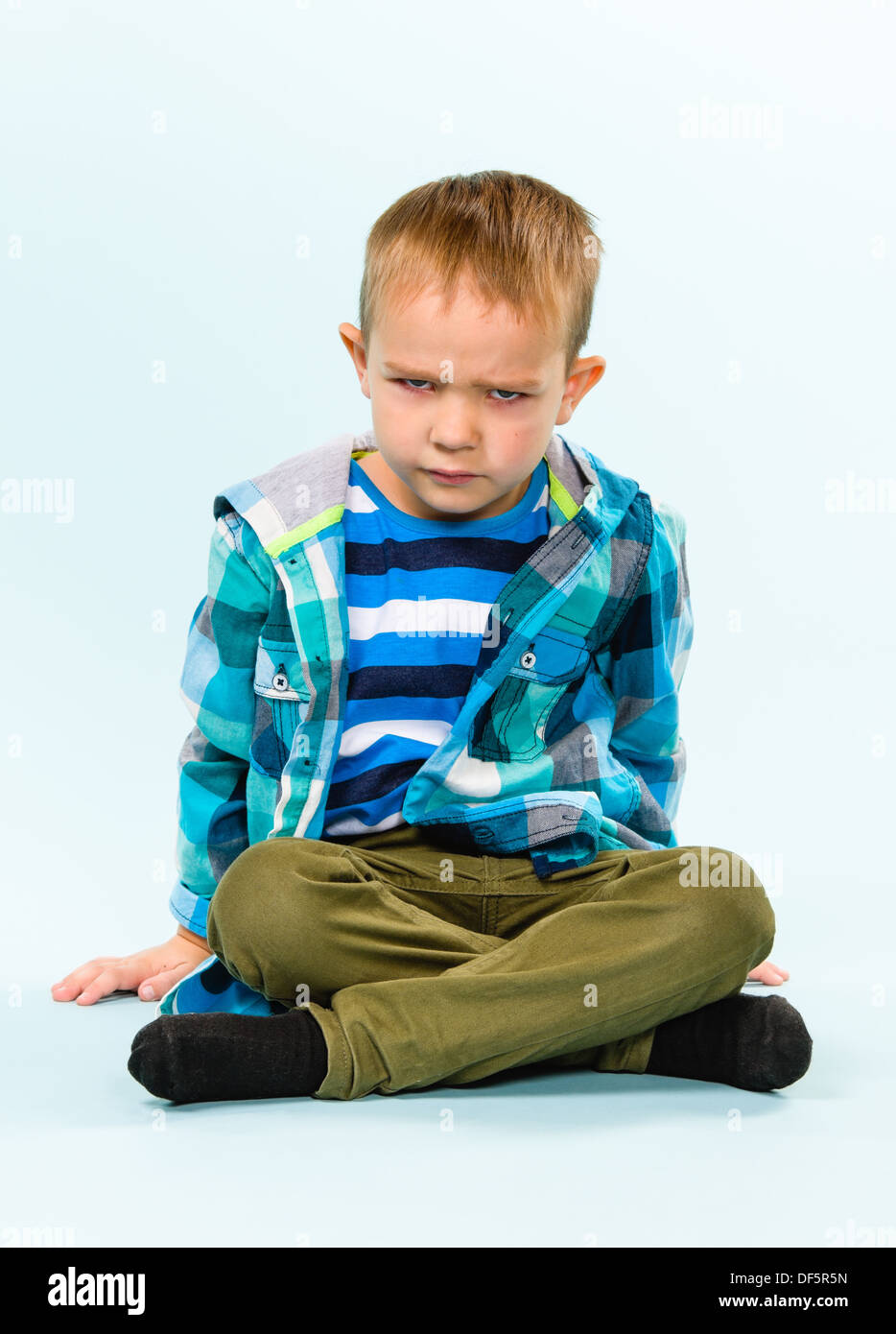 Verspielter kleiner Junge auf hellblauem Hintergrund-studio Stockfoto
