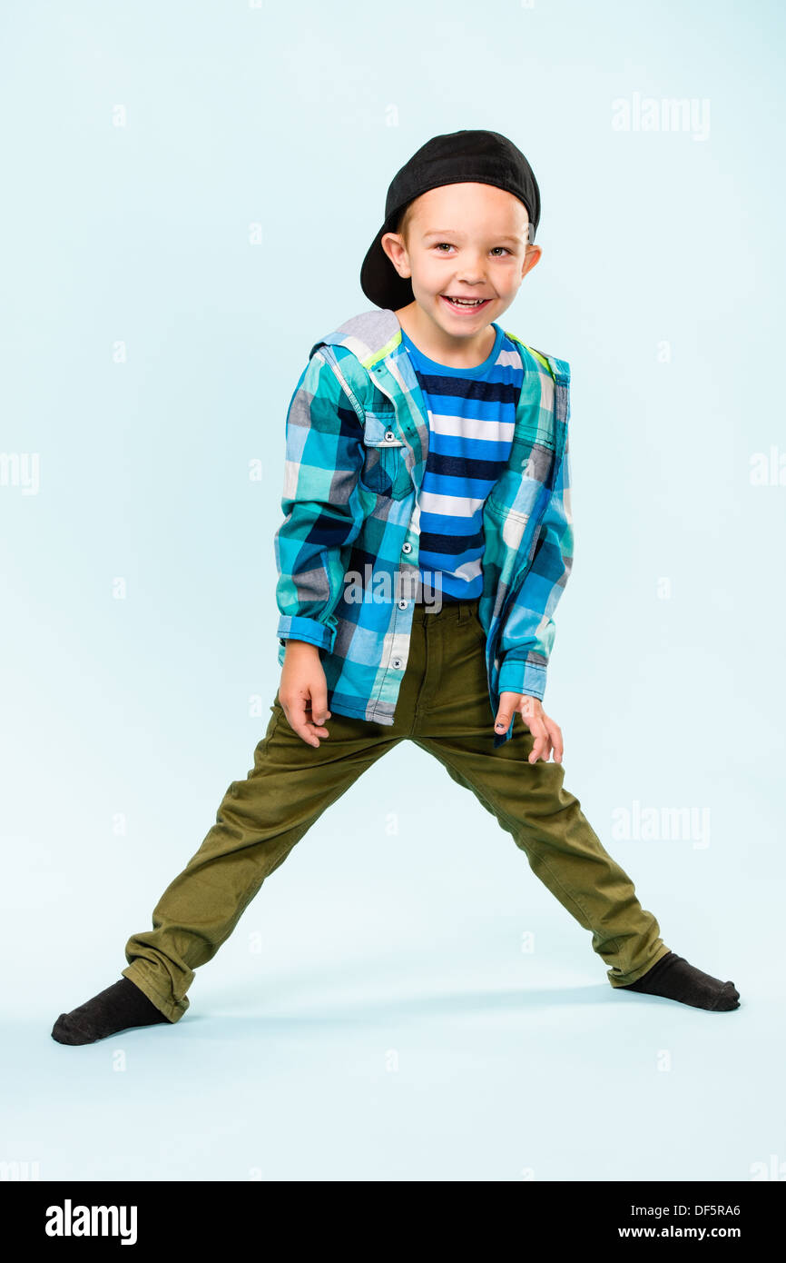 Verspielter kleiner Junge trägt Schirmmütze auf hellblauem Hintergrund-studio Stockfoto