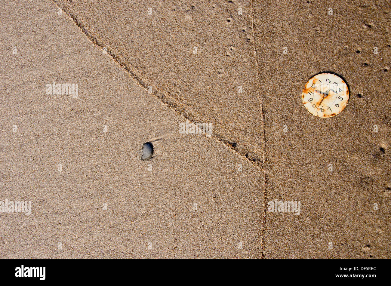 alte rostige Ziffernblatt auf nassen Sand Strand. Zeit-Konzept Stockfoto