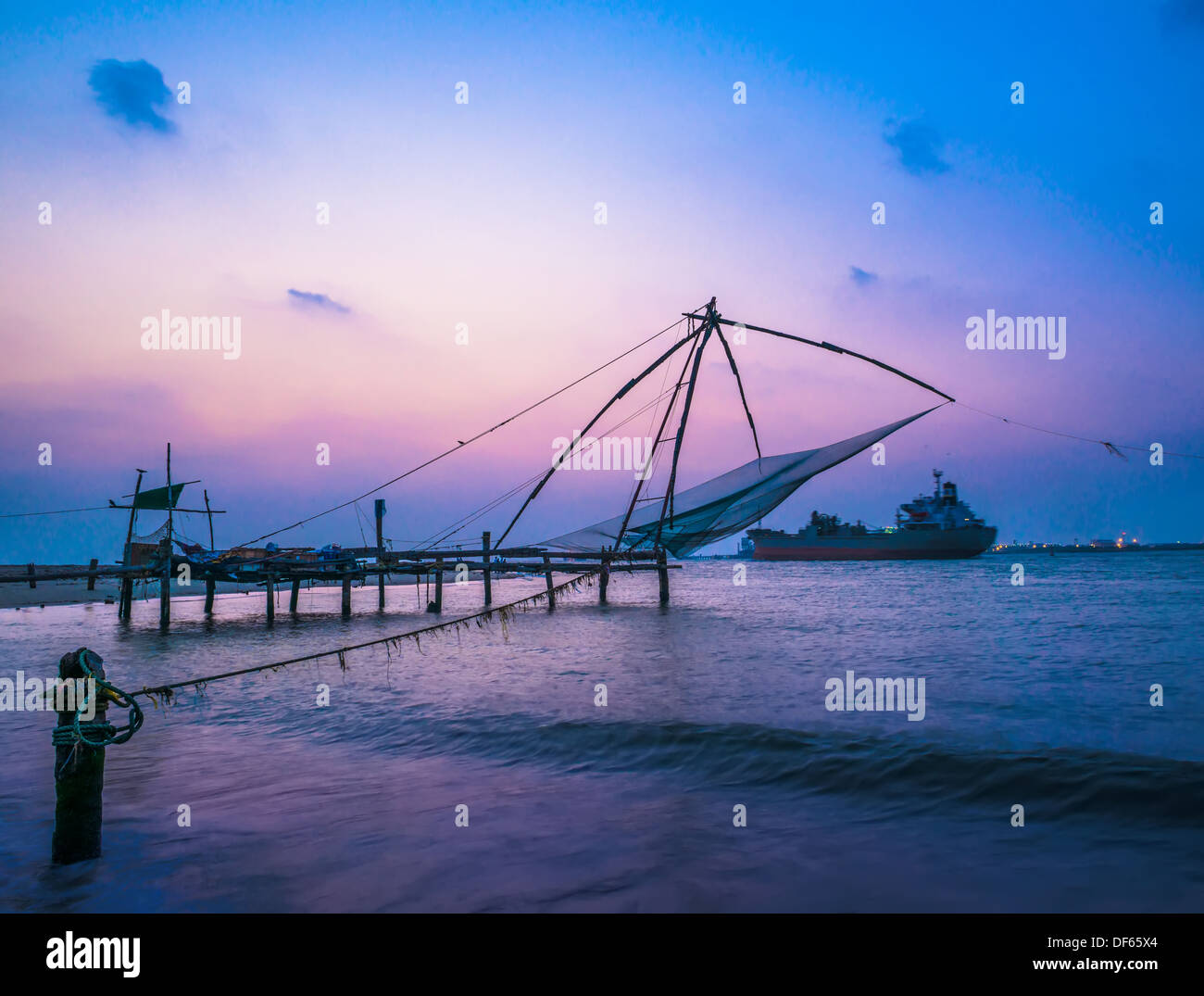Kochi chinesischen Fischernetzen und Schiff bei Sonnenuntergang in Kerala. Fort Kochin, Süd-Indien Stockfoto