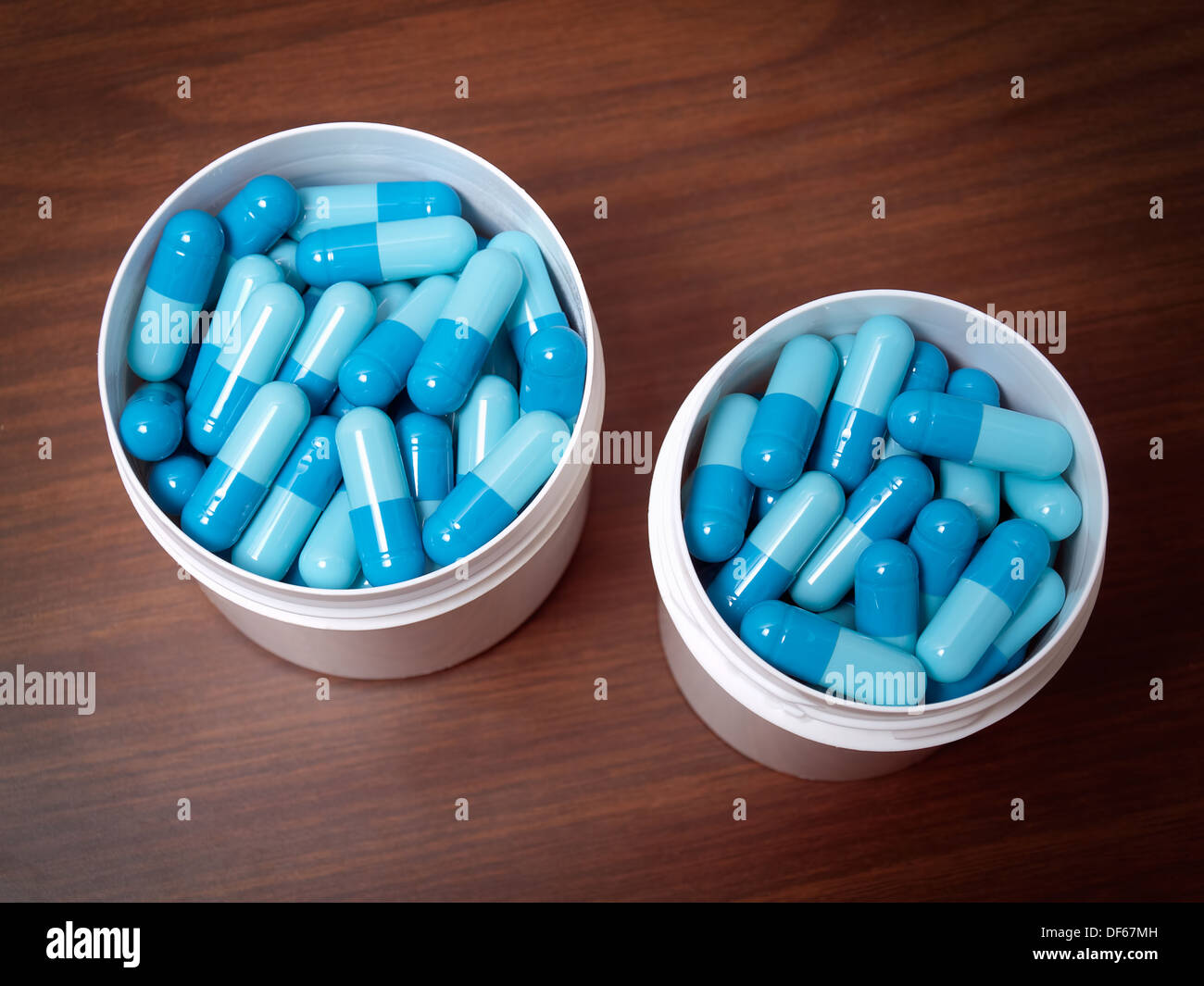 Zwei offene Container mit viel blauen Pillen. Stockfoto