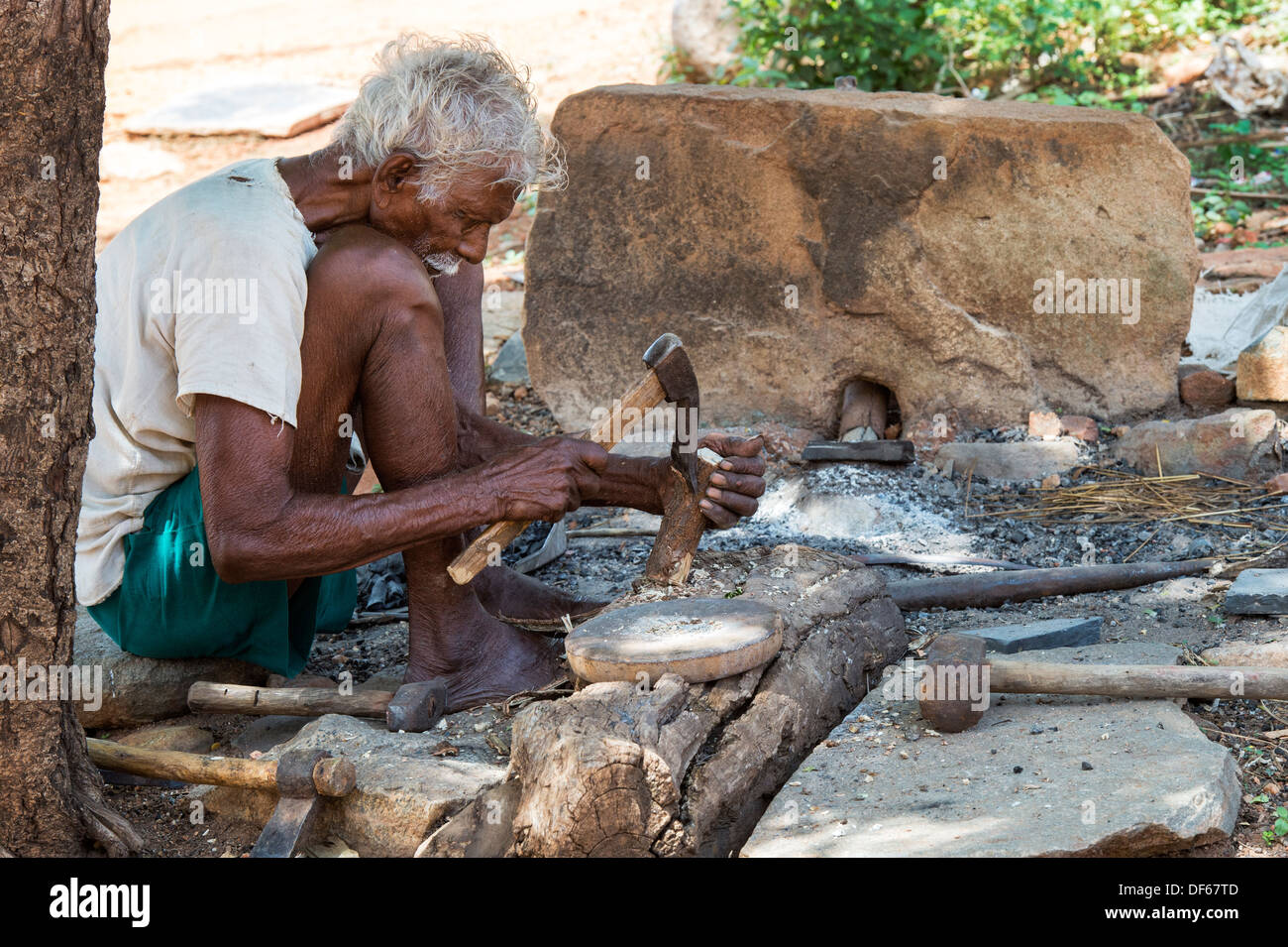 Indische Dorf alte Holz mit einer Axt hacken. Andhra Pradesh, Indien Stockfoto