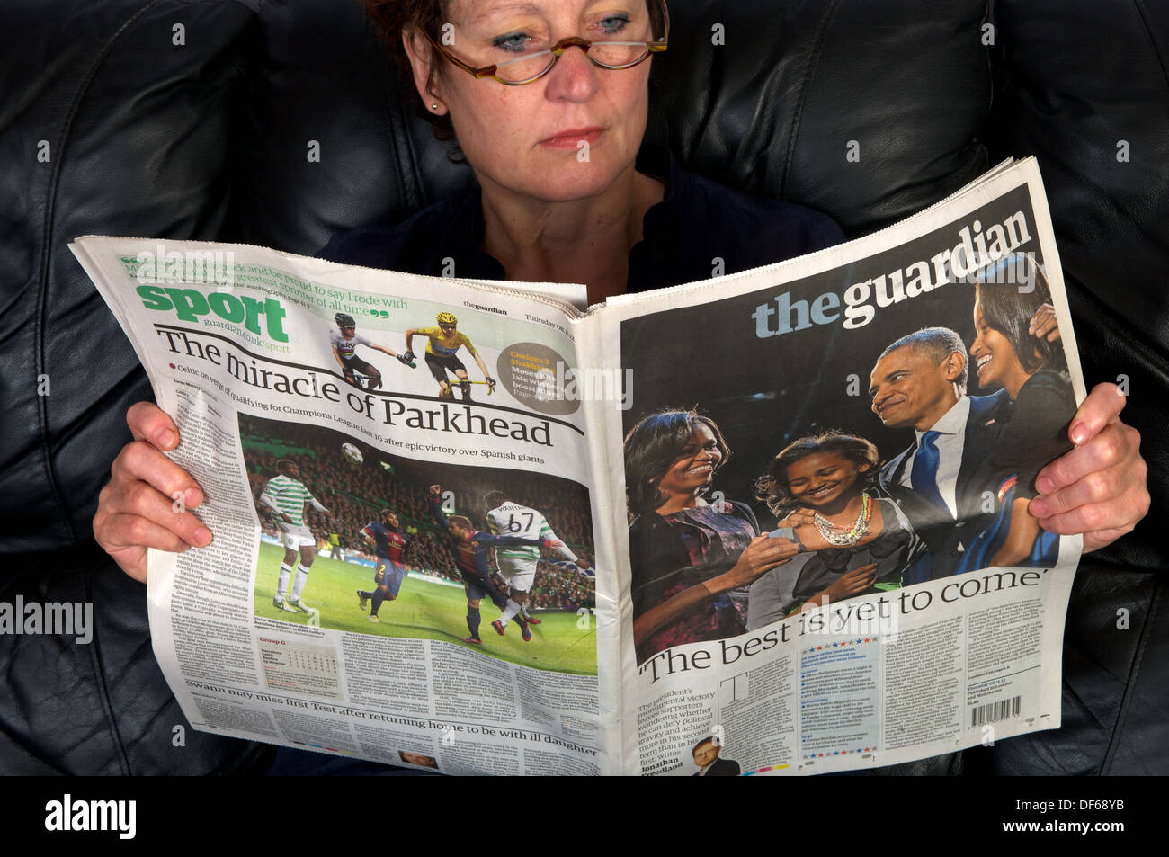 Frau liest eine Kopie der Zeitung The Guardian (08.11.12) Stockfoto