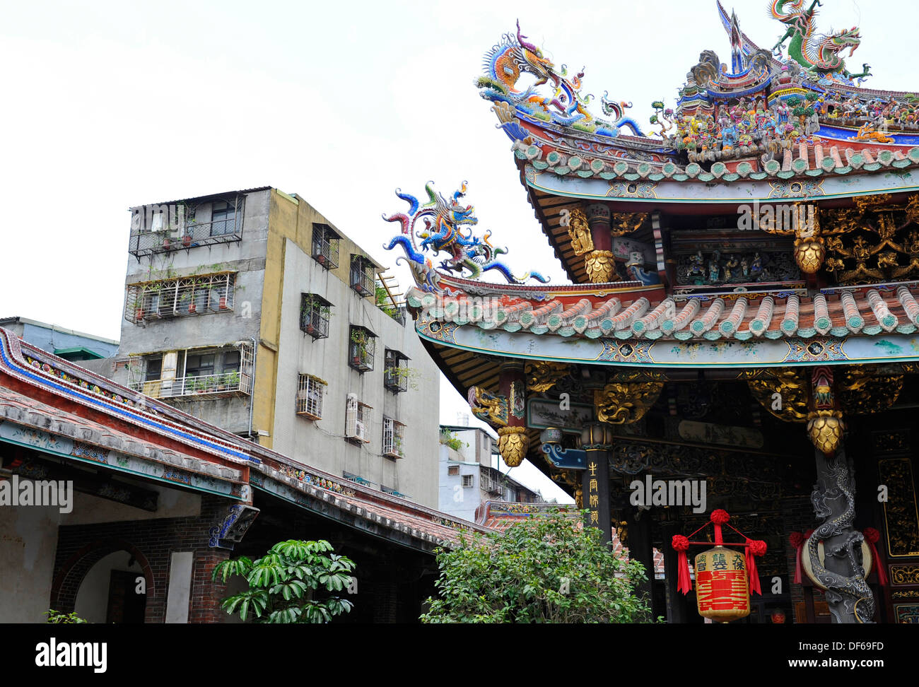 Die feinen dekorativen Skulpturen und Architektur der Baoan Tempel nebeneinander an der Seite der Faden Wohnungen aus Beton hergestellt. Stockfoto