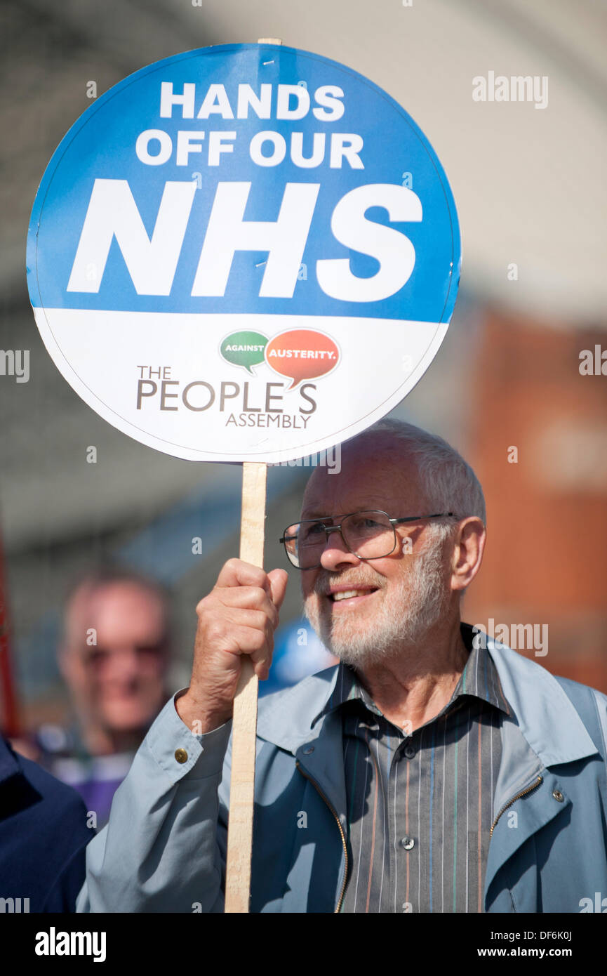 Manchester, UK. 29. September 2013. Ein Mann in seinem fünfziger oder sechziger Jahren hochhalten ein Schild mit der Aufschrift, "Hände weg von unserer NHS", während eine Nord-West TUC organisiert marschieren und Rallye National Health Service (NHS) Arbeitsplätze und Dienstleistungen von Kürzungen und Privatisierungen verteidigen wollte. Der März fällt mit der konservativen Partei Konferenz 2013 in der Stadt statt. Bildnachweis: Russell Hart/Alamy Live News (nur zur redaktionellen Verwendung). Stockfoto